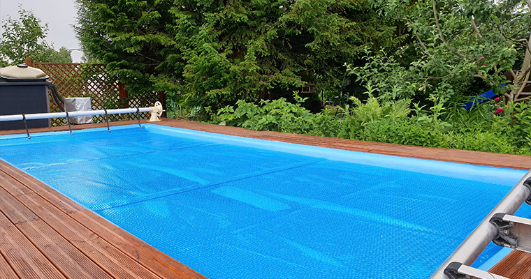 Blaue Sommerabdeckung auf einem rechteckigen Gartenpool